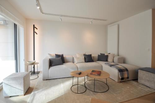 a living room with a couch and a table at Premium modern flat at Zoute Beach 2 bicylcles included in Knokke-Heist