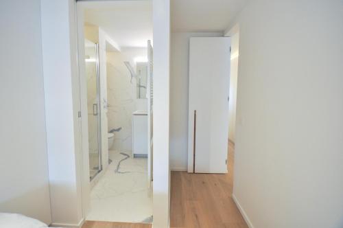 baño con paredes blancas y puerta blanca en Modern flat at Zoute Beach (2 bicylcles included) en Knokke-Heist