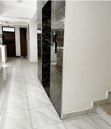 um corredor com colunas de mármore preto num edifício em DelYves Homes em Mombasa