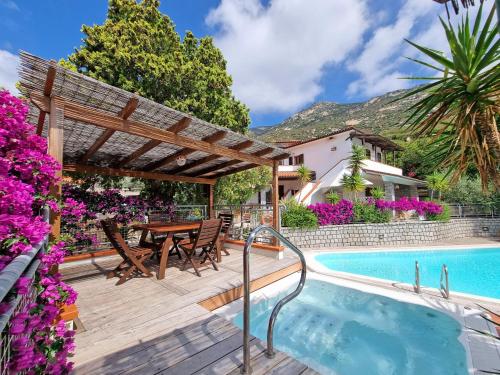a patio with a table and chairs next to a swimming pool at Eco Hotel Montemerlo in Fetovaia