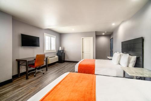a hotel room with two beds and a desk at LYFE INN & SUITES by AGA - LAX Airport in Inglewood