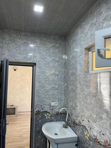 Martuni的住宿－Armani Hotel，一间带水槽、镜子和淋浴的浴室