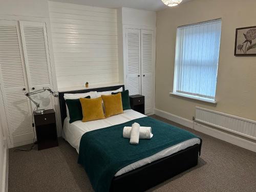 a bedroom with a bed with a teddy bear on it at A Spacious Cartref in Newport in Newport