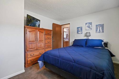 - une chambre avec un lit bleu et une commode en bois dans l'établissement The Brick House, Kellogg ID, à Kellogg