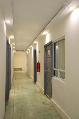 an empty hallway with doors and a tile floor at Hotel El Detalle in Ciudad Valles