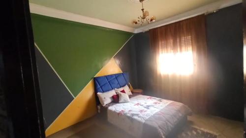 una camera con un letto con una parete blu e verde di شقة مفروشة بالكامل قرب شاطئ أزمور a Azemmour