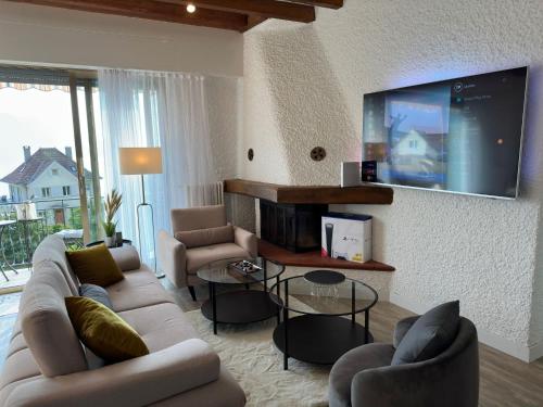 sala de estar con sofá y TV de pantalla plana en Villa Montreux, en Montreux