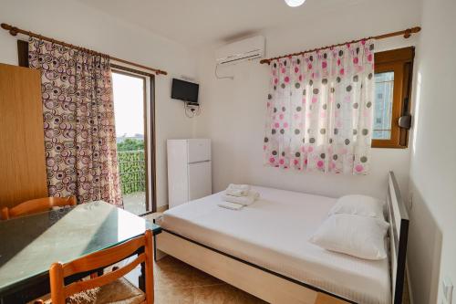 a small bedroom with a bed and a window at Villa Ylli Ksamil in Ksamil