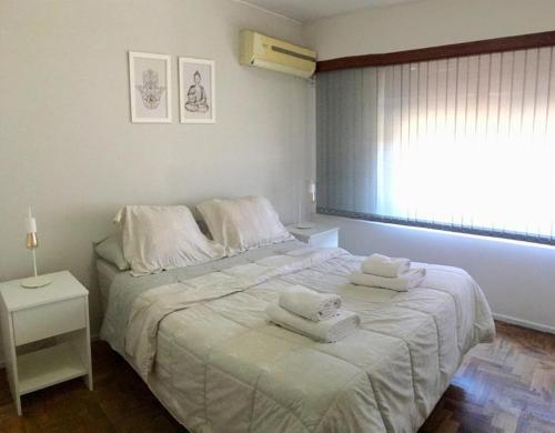 1 dormitorio con 1 cama con toallas en Hermoso depto en la 5ta sección en Mendoza