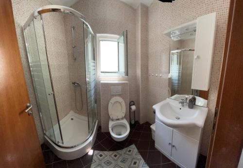 y baño con ducha, aseo y lavamanos. en Apartments Pisačić, en Bibinje