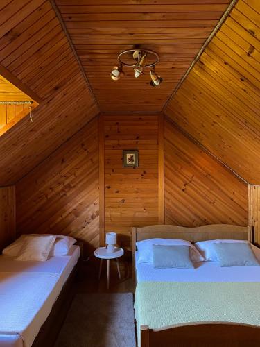 2 camas en una habitación con paredes de madera en Tomasova kuća, en Križevci