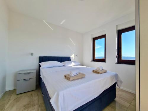 a bedroom with a bed with two towels on it at Apartments Sunflower in Dramalj