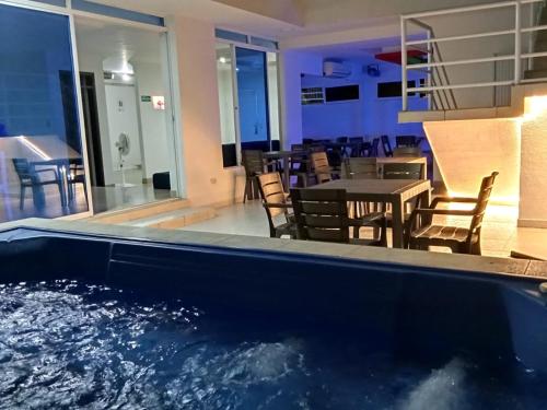 a large swimming pool with a table and chairs at Hotel Boutique Casa Blanca Zarzal in Zarzal