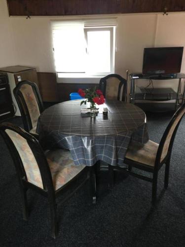 a table and chairs with a table and flowers on it at Prenoćiste Živković in Pirot