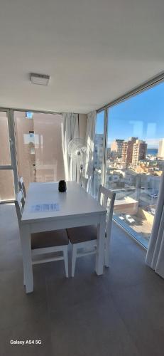a white table and chairs in a room with a window at Amanecerpuertomadryn 4 in Puerto Madryn