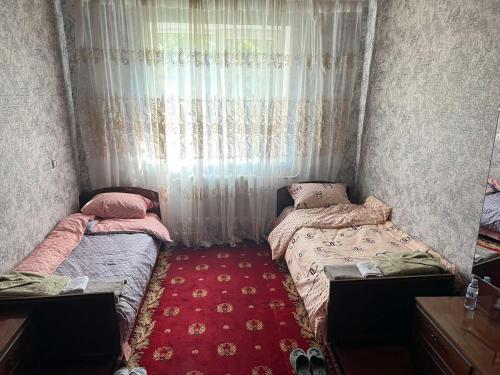 two twin beds in a room with a window at Гостевой дом in Ciorescu