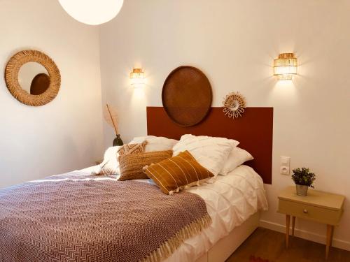 a bedroom with a bed and a mirror on the wall at CASA DAHLIA - Charmant appartement équipé avec grande terrasse in Marseillan