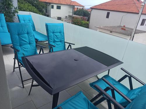 a black table and chairs on a balcony at AdriaApart in Sveti Filip i Jakov
