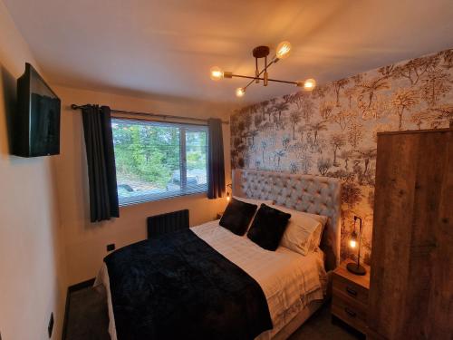 1 dormitorio con cama y ventana en Bowness - 3 Bed - Hot Tub House, en Bowness-on-Windermere