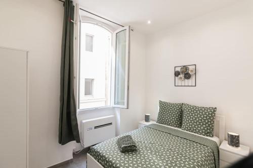 une petite chambre avec un lit et une fenêtre dans l'établissement Super T2 au Vieux Port Climatisé, à Marseille
