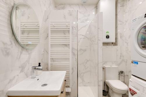 une salle de bain blanche avec un lavabo et des toilettes dans l'établissement Super T2 au Vieux Port Climatisé, à Marseille