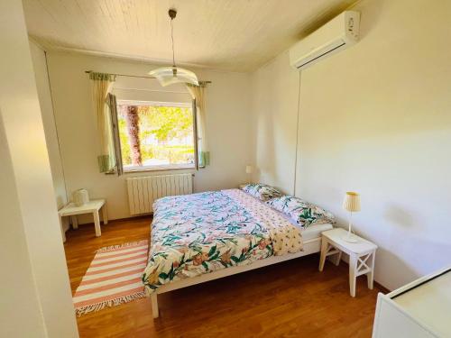 a small bedroom with a bed and a window at Little Sunflower in Matulji