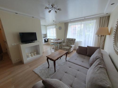 a living room with a couch and a table at Cozy centre apartment KKE in Ventspils