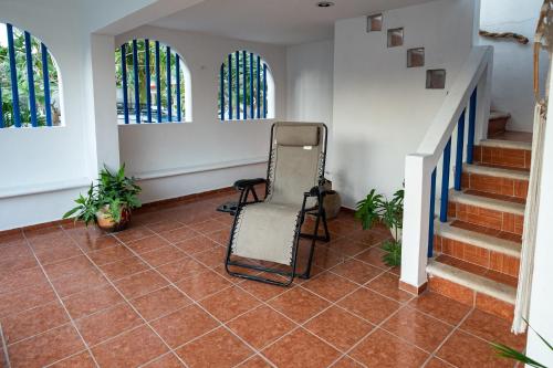 a room with a chair and stairs with stained glass windows at Beach house in Chuburná
