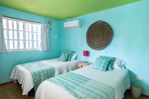 ChuburnáにあるBeach houseの青い壁のドミトリールーム ベッド2台
