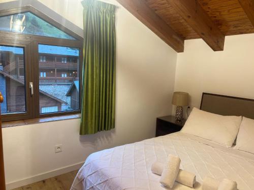 索爾德烏的住宿－Apartamento Dúplex Vistas al Valle de Incles Orenetes WiFi，一间卧室设有一张床和一个窗口