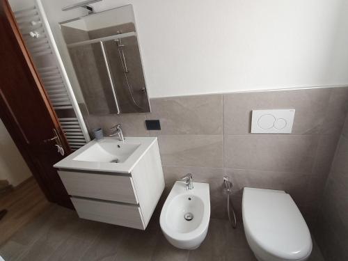 a bathroom with a white sink and a toilet at A casa di Gigi in Tione di Trento