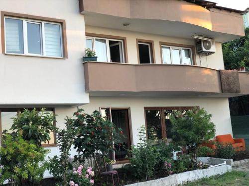 a white house with a balcony and some plants at Trabzon Blue Sea House in Akcaabat