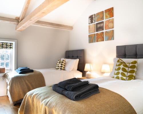 dwa łóżka w pokoju z dwoma łóżkami w obiekcie The Coach House at Jervaulx w mieście Ripon