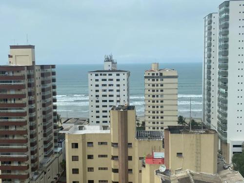 a group of tall buildings with the ocean in the background at Linda Cobertura vista mar no Residencial Affinity in Praia Grande