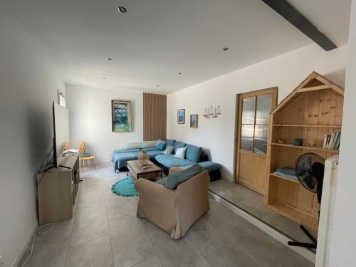 a living room with a blue couch and a tv at Villa Pierre et Mer, maison 6 personnes a deux pas des plages in Hyères