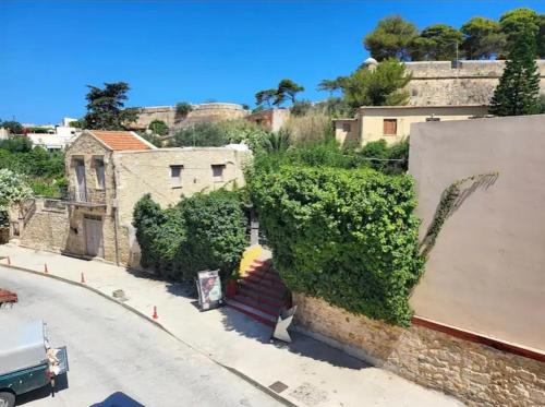 a building with a mural of a person with a umbrella at Fortezzino in Rethymno