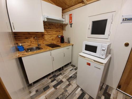a small kitchen with a microwave and a refrigerator at La chocita de Tortosa in Tortosa