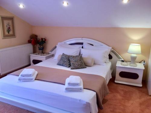 een slaapkamer met een groot wit bed en handdoeken bij Villa VS in Vathí