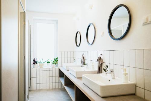 a bathroom with three sinks and mirrors on the wall at Belsőörs - ház lélekkel in Felsőörs