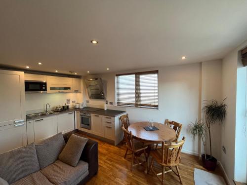 a kitchen and a living room with a table and a couch at Avalon apartment city center of brighton & hove in Brighton & Hove