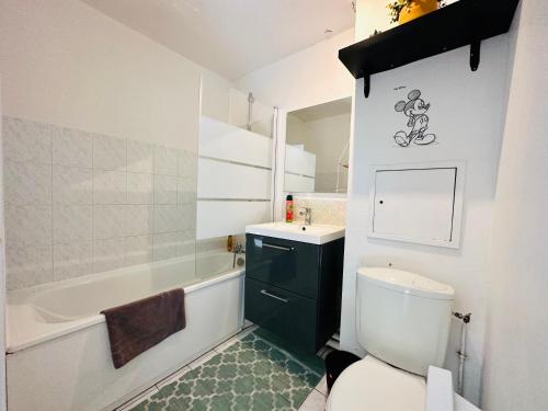 a bathroom with a toilet and a sink and a tub at Appartement Eco 6 personnes in Magny-le-Hongre