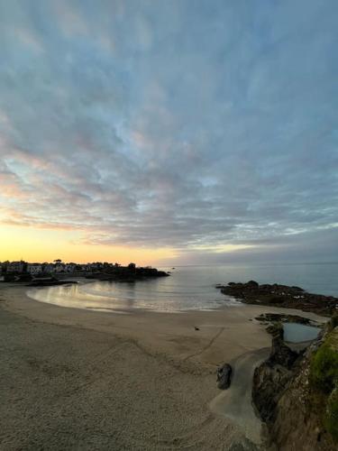 a view of a beach with the ocean and the sky at Maison rénové bourg de Plourhan in Plourhan
