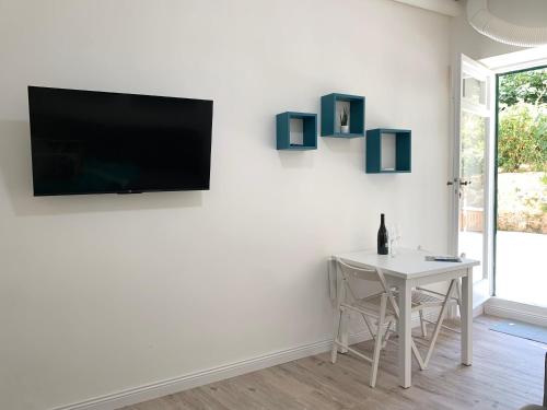uma sala de estar com uma mesa e uma televisão na parede em Casetta Lorica Porto Santo Stefano em Porto Santo Stefano