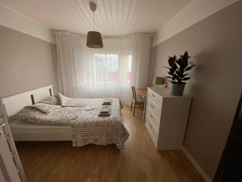 a bedroom with a bed and a dresser and a window at Videviku Apartments in Tallinn