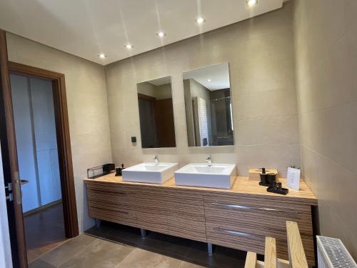 a bathroom with two sinks and a mirror at PENEMA VILLA in Hersonissos