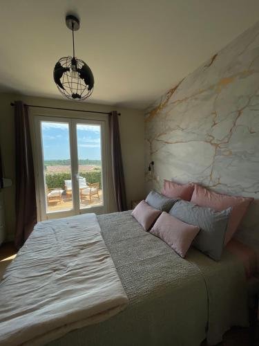 a bedroom with a large bed and a large window at Chambre d'hôtes avec Jacuzzi Ventoux Cocoon in Bédoin