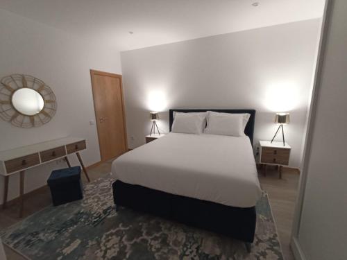 a bedroom with a white bed and two night stands at FAMILY Apartamento I in Coimbra