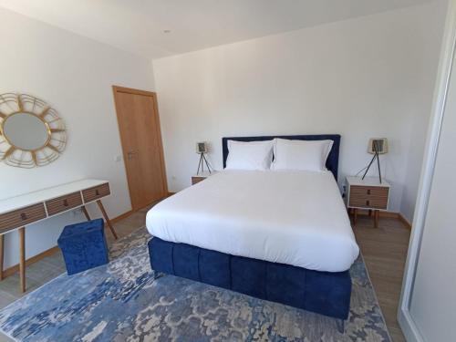 a bedroom with a large white bed and a desk at FAMILY APARTAMENT I in Coimbra