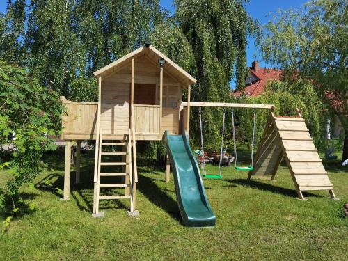 una casa de juegos con un tobogán y un columpio en Wodna Ostoja z kominkiem nad jeziorem Selment, en Buczki