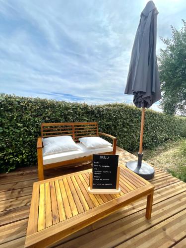 a wooden deck with a bed and an umbrella at Chambre d'hôtes avec Jacuzzi Ventoux Cocoon in Bédoin